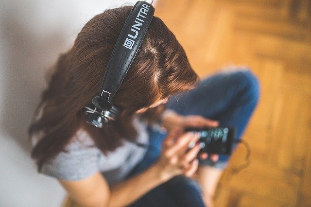Lyssnar på ljudböcker, hörlurar och mobil